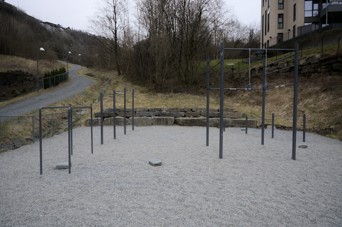 Outdoor gym with horizontal bars of various heights, dip bars and rings.