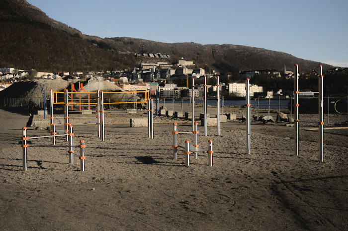 Temporary outdoor gym at Bystranden, a beach under construction. Includes various horizontal bars and monkey bars.